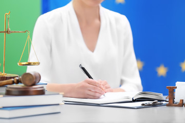 Female judge working with documents and law accessories on table