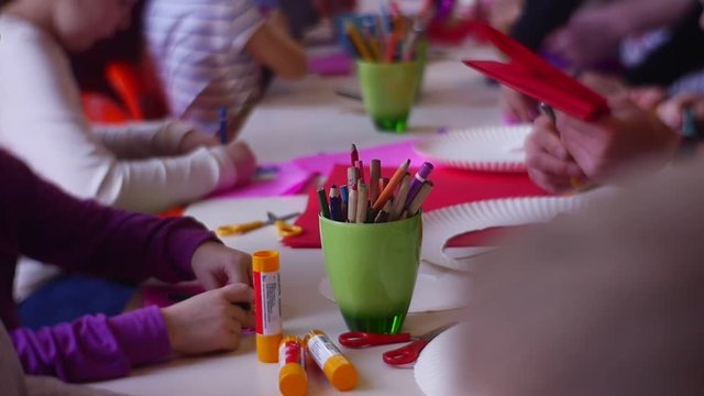 Children Sit at a Table in a Kindergarten