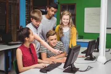 Smiling students studying in computer classroom