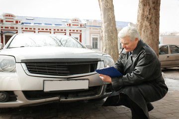 Loss adjuster inspecting car after accident