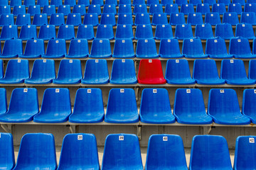 Dark blue rows of seats on the stadium. One red seat. © ProstoSvet