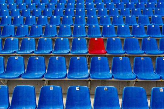 Dark blue rows of seats on the stadium. One red seat.