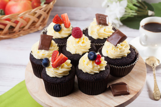 Chocolate capkake with cream and berries, raspberry, strawberry, blueberry, still life, close-up