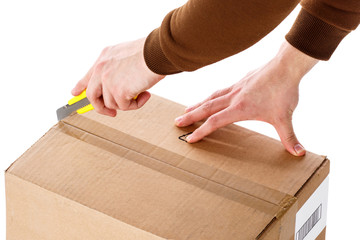 The man opens the box with a sharp cutting knife. Close-up. Isolated on white background