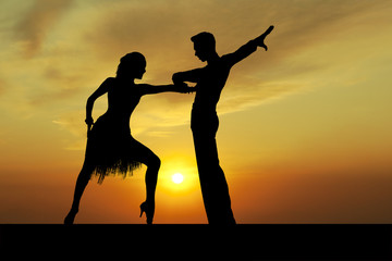 Silhouette couple in the active ballroom dance on sunset