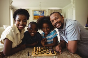 Portrait of family playing chess together at home 