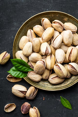 Pistachios nuts on dark background, top view, healthy snack