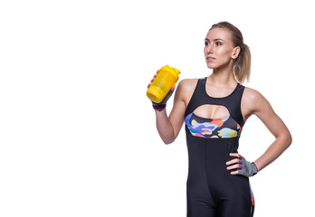 Attractive athletic woman relaxing after workout with shaker isolated over white background. Healthy girl drinks whey protein. Copyspace for text.