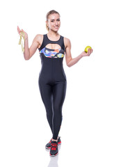 Slim and healthy young woman wearing sportswear tracksuit holding measure tape and green apple isolated on white background. Weight loss and diet concept.