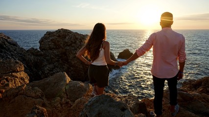 Pareja frente a un atardecer rojizo