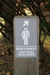 Gender neutral restroom sign that says, WHO CARES JUST WASH YOUR HANDS.