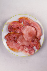 Bacon on white plate. Grilled rashers. View from above, top studio shot
