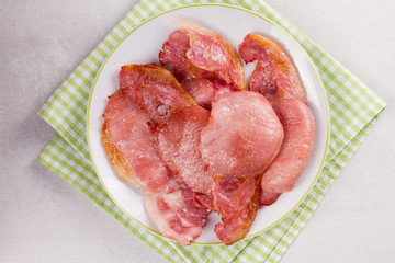Bacon on white plate. Grilled rashers. View from above, top studio shot