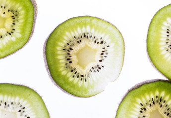 Transparent kiwifruit slices close-up on the white