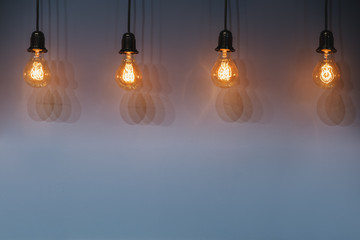 Decorative antique edison style light bulbs against wall background.