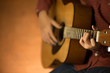 women playing acoustic guitar close-up