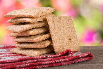 stack of crisp bread on a wooden table with blurred garden background