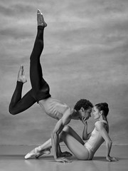 Couple of ballet dancers posing over gray background