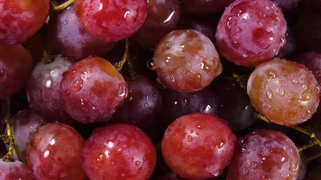 Excellent top view of grapes close up, water sprinkling and rotating against the clock. Vibrant flat lay of yummy fruit dessert with amazing texture in great 4k clip. Eco product for healthy food.