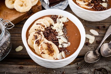 Chocolate smoothie bowl with banana, chia seeds and almond chips