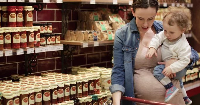 Pregnant mother with daughter grocery shopping