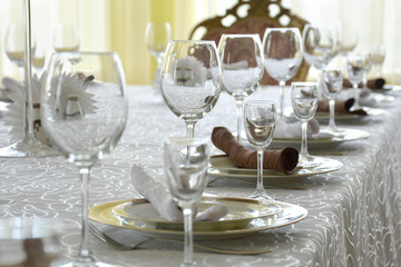 Clean dishes, glasses and plates on the table in the restaurant.