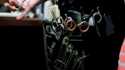 barber takes scissors from a full tool board slow motion good