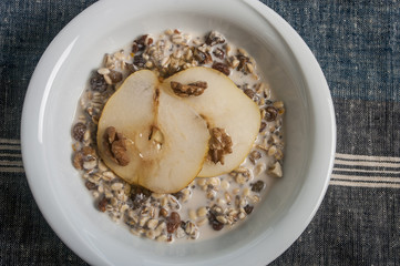 Oatmeal with pear and walnuts in the bowl
