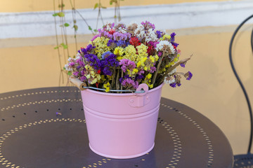 Wildflowers in a colorful bucket on the table