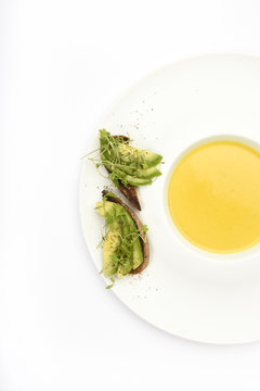Yellow soup with pumpkin, lentils, turmeric and ginger with avocado bread