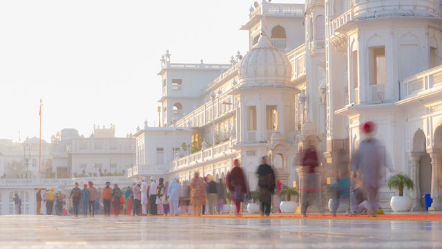 Tourists and worshipper walking inside the Golden Temple complex at Amritsar, Punjab, India, the most sacred icon and worship place of Sikh religion. Blurred motion, long exposure.