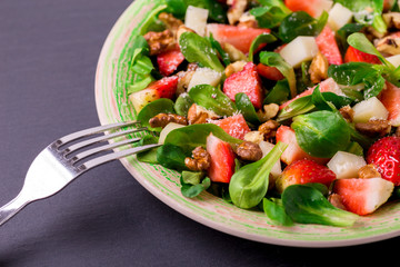 Salad with strawberry, spinach, walnuts and goat cheese