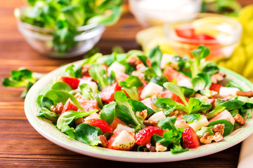 Salad with strawberry, spinach, walnuts and goat cheese