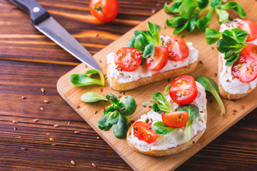 Bruschetta with ricotta, spinach, corn salad and cherry tomatoes