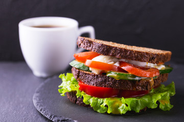 Sandwich with cherry tomatoes, cucumber and lettuce and coffee
