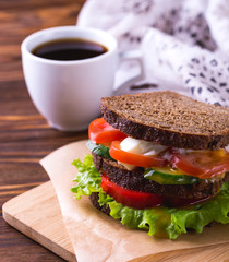 Sandwich with cherry tomatoes, cucumber and lettuce and coffee