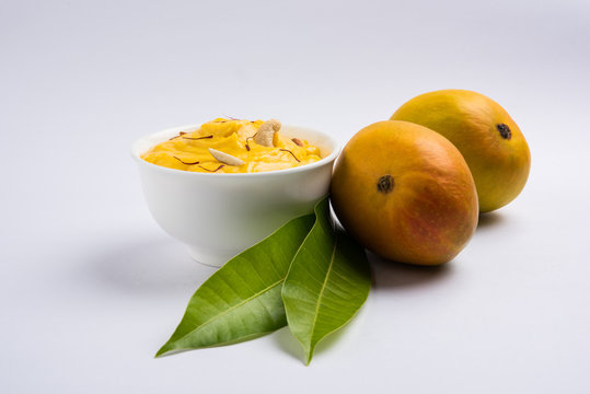 hapus or alphonso Mango pudding / Mango shrikhand or srikhand or amrakhand - Mango dessert with condensed milk magoes and nuts, selective focus over white background