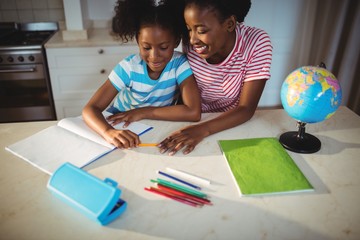 Mother assisting daughter with homework 