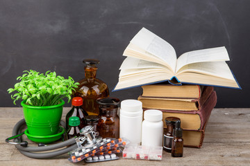 Medical education concept - books, pharmacy bottles, stethoscope in the auditorium with blackboard