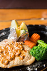delicious pork chop steak with potato and vegetable on hot pan