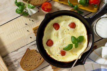 Breakfast background. Scrambled eggs with fresh tomatoes and suluguni cheese. The concept of a healthy diet and diet.