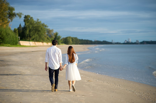 Happy Romantic young Couple Enjoying Beautiful Sunset Walk on the Beach.