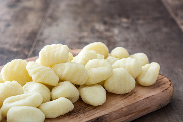 Uncooked potato gnocchi on wooden table
