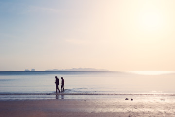 friends walking in the sea beach, lonely summer season vintage color tone.