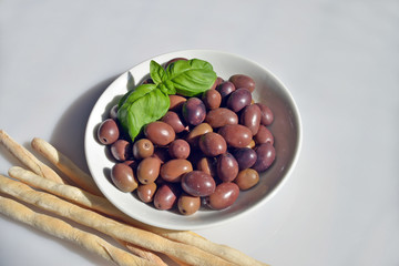 olive della riviera italiana  close-up di un piattino riempito con olive della riviera, pronte da gustare accompagnate da grissini caserecci
