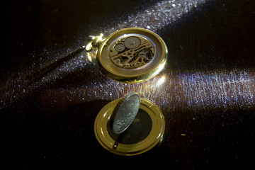 old pocket watch with a money in chiaroscuro