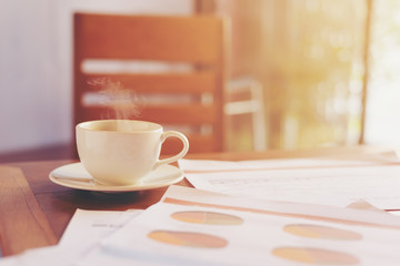 Hot coffee on the table with business document