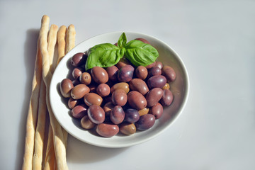 olive della riviera italiana  close-up di un piattino riempito con olive della riviera, pronte da gustare accompagnate da grissini caserecci