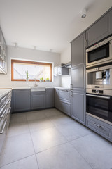 Fototapeta na wymiar Modern kitchen with grey furniture