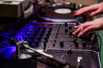Fototapeta na wymiar Close up Dj hands on equipment deck and mixer with vinyl record at party. Selective focus